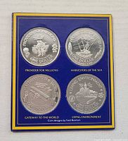 Front view of four commemorative coins in presentation card