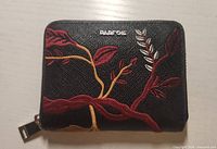Front view of Parfois black faux leather mini wallet with floral embroidery