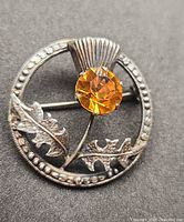 Front view showing thistle design and orange stone