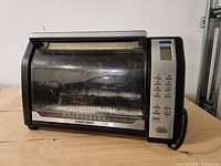 Front view of Black & Decker toaster oven showing digital controls and glass door