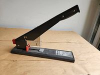 Full view of stapler left side, handle raised