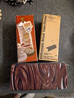 Boxed milk frother, Pampered Chef bread tube box, swirl tin closed
