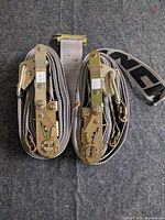Two rolled Ancra ratchet straps side by side showing ratchet hardware and hooks