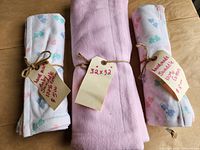 Three rolled blankets with size and price tags visible