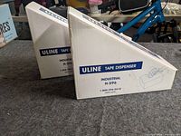 Two retail cartons showing Uline Tape Dispenser Industrial H-596 labeling