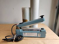 Uline impulse sealer side view with both plastic rolls behind