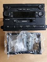 Front view of Ford radio showing controls and included bezel and sleeve