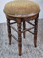 Full view of stool showing turned legs, stretchers, upholstered seat