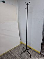 Full view of black metal coat rack standing upright