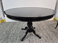 Full view of black round pedestal dining table