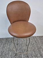 Front view of brown leather swivel bar stool
