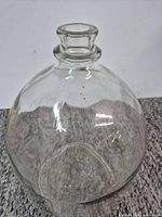 Full view of clear CRISA glass carboy showing shape and neck