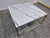 three-quarter view showing full table, marble top, and metal frame