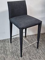 Full view of chair showing upholstery, leg design and footrest