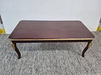 Front view of rectangular brown wood coffee table on carpet