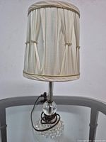 Full lamp showing shade, stem, and glass base