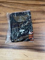 Front of sealed camo Anti Social Social Club T-shirt showing size label and partial orange logo