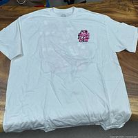 Front of white T-shirt showing small chest pink camo logo