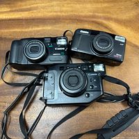 Front view of all three Canon film cameras showing lenses and model markings