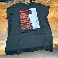 Full view of black Scarface T-shirt laid flat showing front graphic
