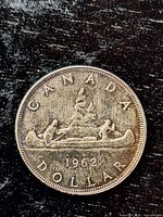 Reverse of 1962 Canadian silver dollar showing canoe design