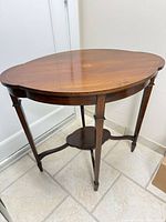 Full view of the mahogany side table showing legs and stretcher shelf