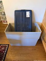 Stack of five grey totes with one lid shown