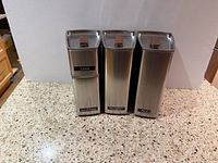 Front view of three tall and one short stainless canisters showing labels coffee, sugar, flour (with missing letter) and tea