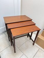 three teak stacking tables stacked