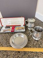 Group shot showing both pewter tankards, carving set in case and stainless dish for full lot overview