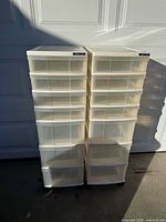 Front view of two plastic rolling storage towers with drawers visible
