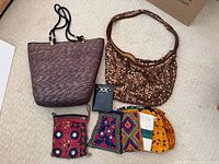 All items laid out: sequin bag, woven tote, DOC wallet, six pouches