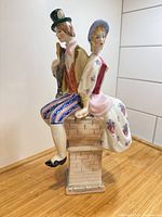 Full view of porcelain figurine showing both characters and brick base