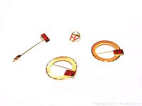 Four gold pins displayed on a white background, showing the stick pin, two round pins, and a small tack pin all tagged.