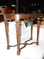 Front and side view showing the ornate carved apron and detailed legs of the vintage hall table.