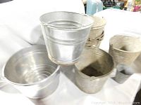 Photo showing a variety of metal pails in different sizes and finishes including galvanized and weathered metal.