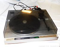 Yamaha P-500 turntable covered with tinted dust cover, cables visible behind.