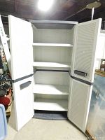 Open view of heavy duty plastic storage cabinet showing four shelves inside, with textured inside of doors and black pull handles.