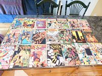 Photo showing 21 bagged vintage X-Men comic books laid out flat on a table with visible covers.