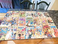 Photo of 20 vintage comic books by various Marvel and DC series laid out on a table.