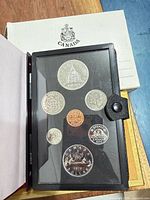 Open display case showing all seven coins and outer box