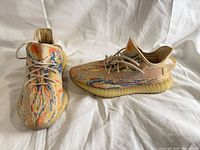 Top and side view of both sneakers showing upper pattern and laces