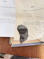 Shale fragment with trilobite fossil and accompanying typed sheet on table