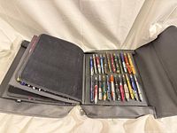 Open display case showing multiple panels filled with pens