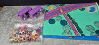 play mat, two purple vans, sealed bag of figures displayed on tabletop