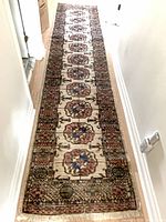 Full length view of wool runner laid in hallway showing overall pattern and fringe