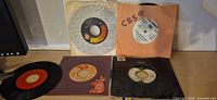 Group shot of all five 7" singles with assorted sleeves