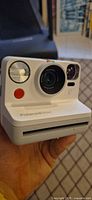 Front view of white Polaroid Now camera held in hand
