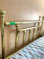 Full view of brass-plated headboard attached to bed
