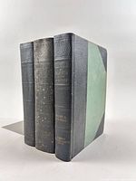 Three volumes standing upright showing spines and boards